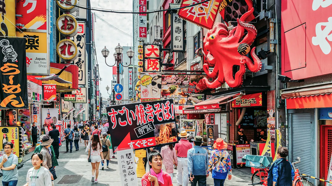 Japan, Kansai, Osaka, Dotonbori, Streetfood Belebte Straßen mit bunten Schildern und Streetfood in Dotonbori. Osaka, Kansai, Japan.