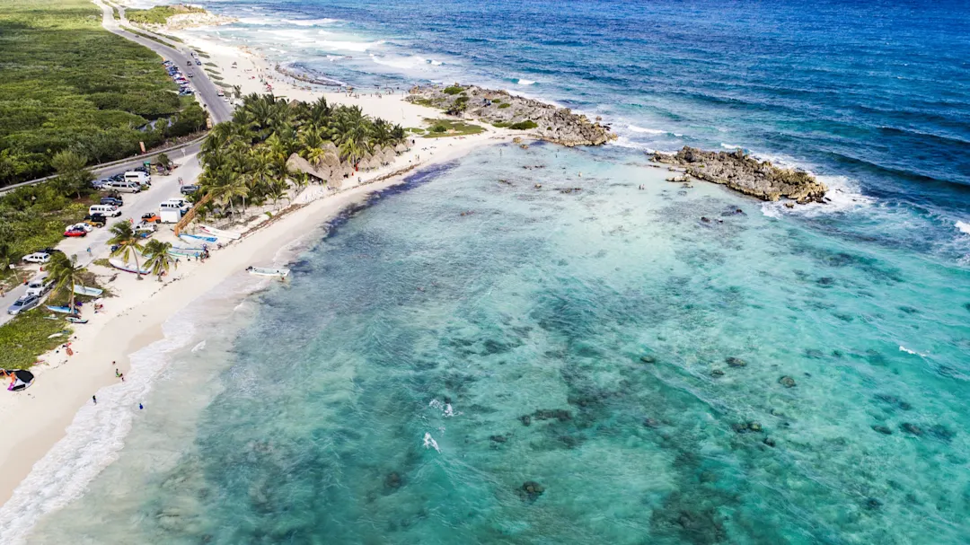 Luftaufnahme einer tropischen Strandküste mit Palmen und kristallklarem Wasser. Cozumel, Quintana Roo, Mexiko.