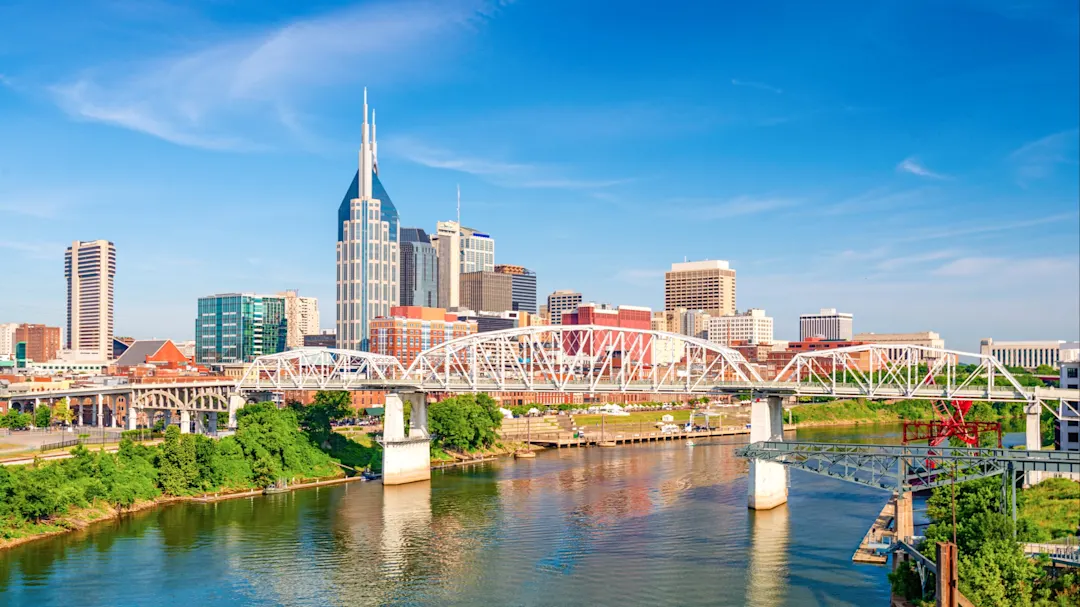 Panoramablick auf die Skyline von Nashville mit Fluss und Brücke im Vordergrund. Nashville, Tennessee, USA.