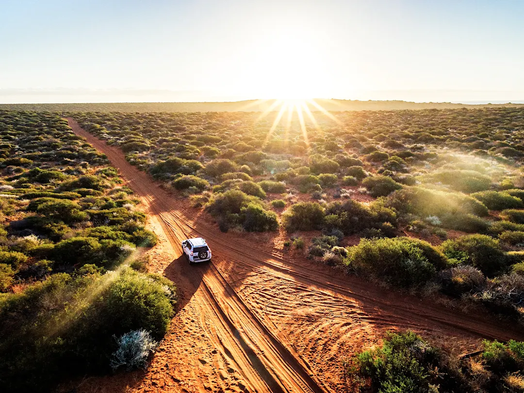 Offroad-Fahrzeug auf Sandpiste bei Sonnenaufgang, Outback, Western Australia, Australien.
