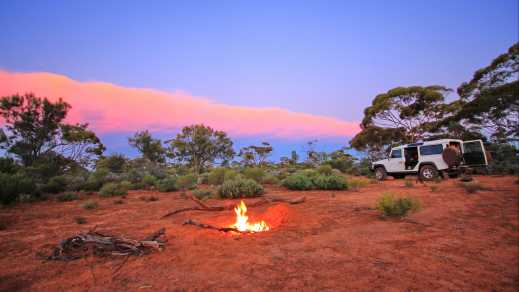 Abendliches Feuer im australischen Outback während eines Camper-Urlaubs.