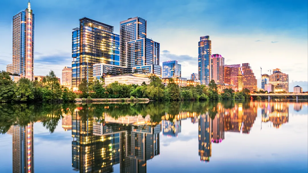 Skyline von Austin mit Reflexionen im Lady Bird Lake während der Abenddämmerung. Austin, Texas, USA.