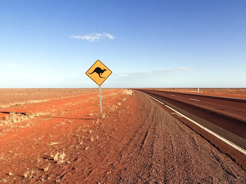 Straße mit Känguru-Warnschild in der Wüste. Outback, South Australia, Australien.
