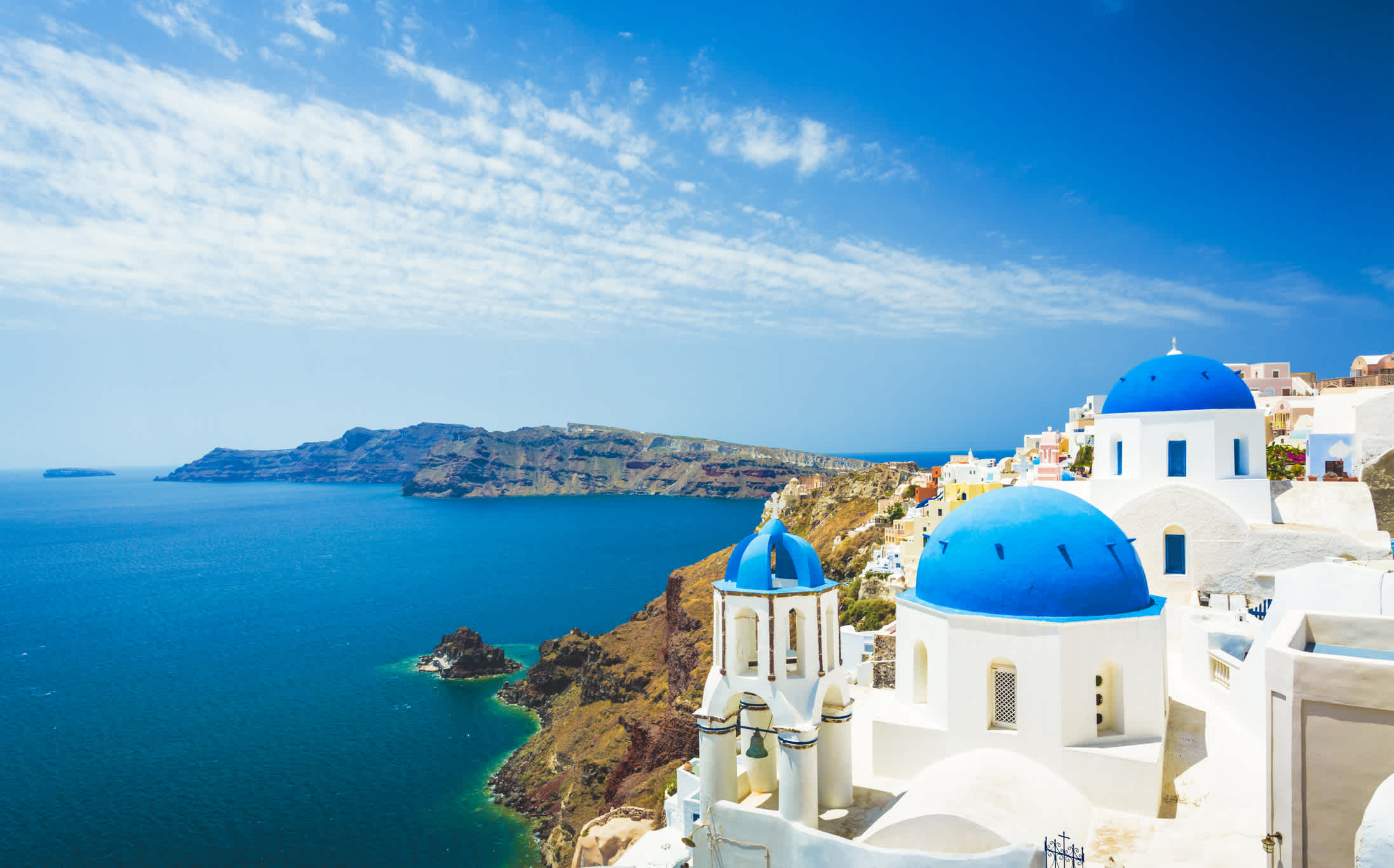 Le magnifique village d'Olbia, sur l'île de Santorin en Grèce, et ses bâtiments blancs aux toits bleus. Une île des Cyclades particulièrement prisée par les voyageurs du monde entier.