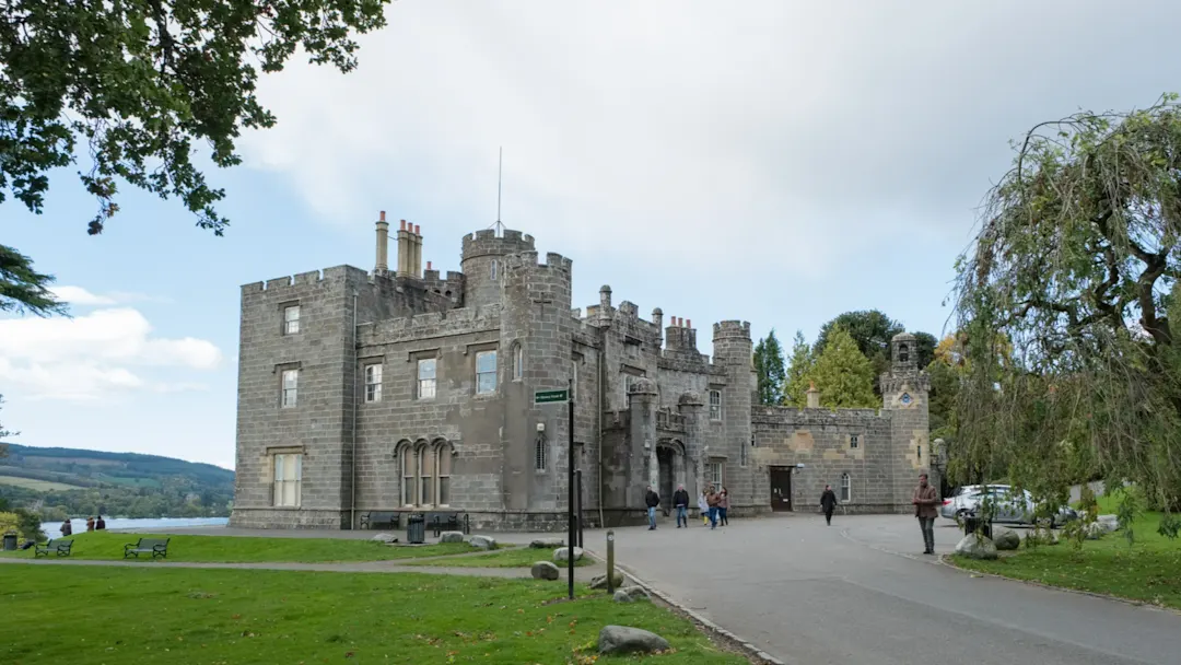 Balloch Castle, Loch Lomond, Schottland Blick auf ein altes Schloss aus grauem Stein und eine grüne Parklandschaft