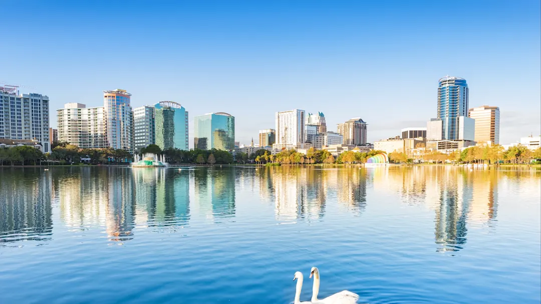 Panoramablick auf die Skyline von Orlando und den Lake Eola mit Schwänen. Orlando, Florida, USA.