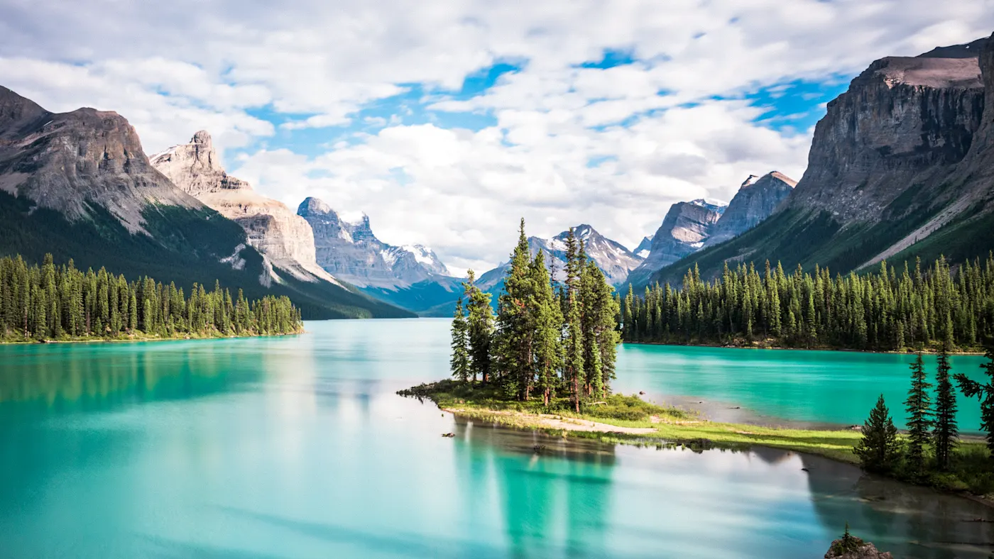 Alberta, Kanada. Idyllische Insel mit Bäumen im türkisfarbenen Maligne See, umgeben von beeindruckenden Bergen. Jasper Nationalpark, Alberta, Kanada.