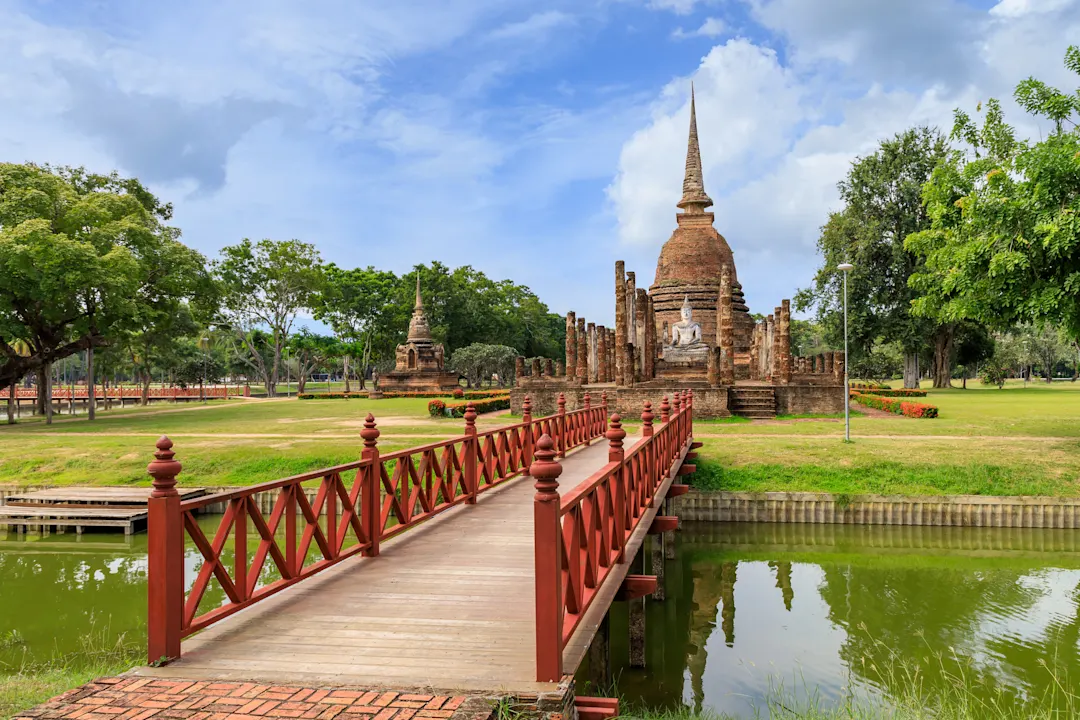 Wat Sa Si Tempel, Sukhothai, Thailand Blick auf eine rote Brücke, die zum Wat Sa Si Tempel führt