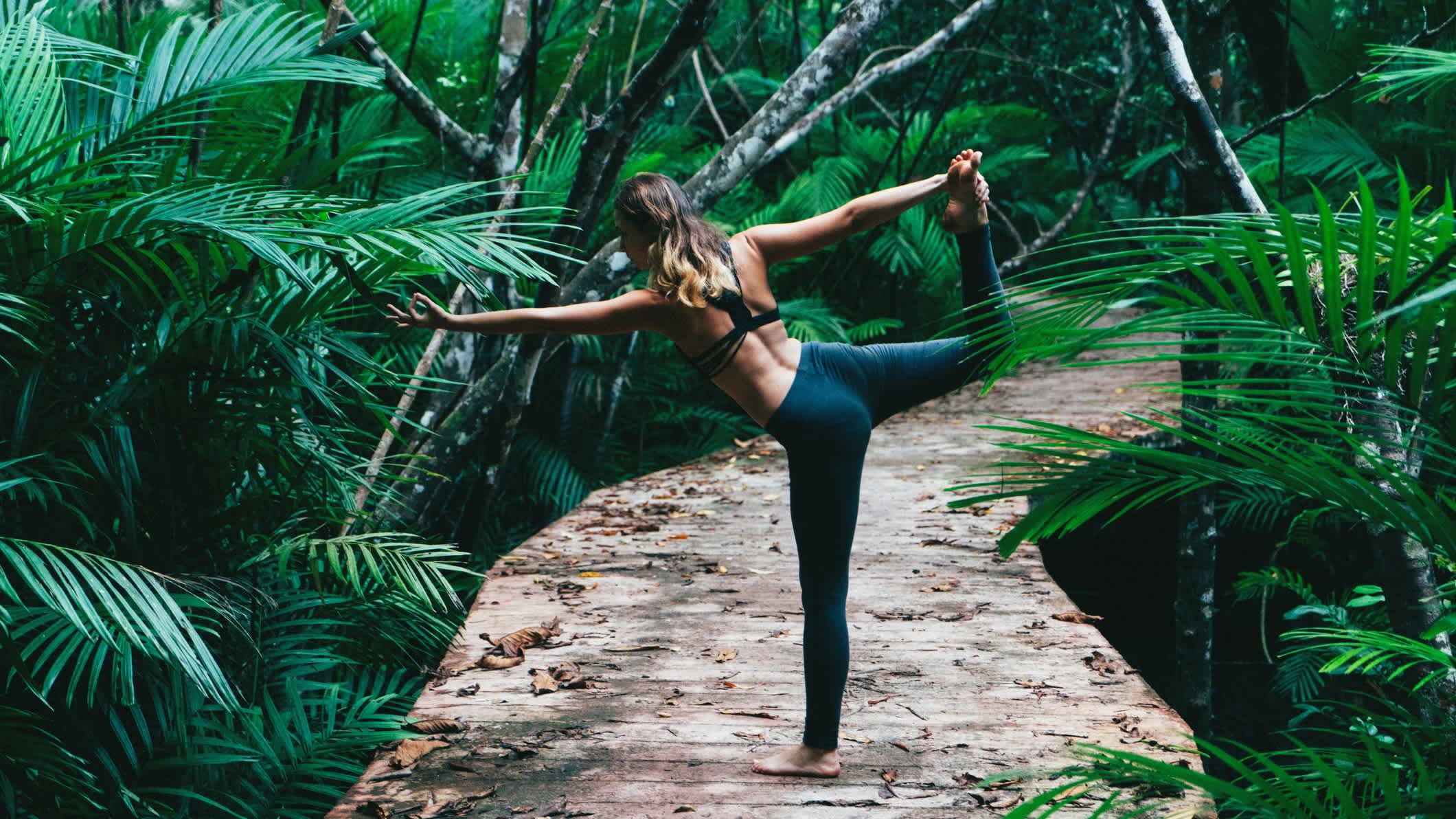 Frau macht Yoga auf tropischen Wald