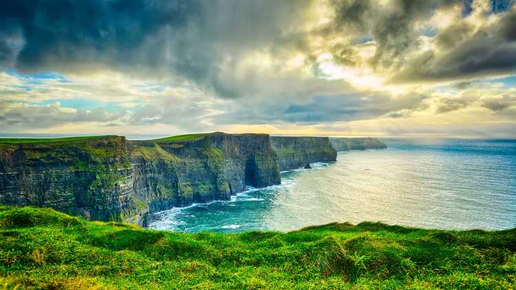 Europe, Ireland, Cliffs of Moher, grassy cliffs looking over the Atlantic Ocean.
