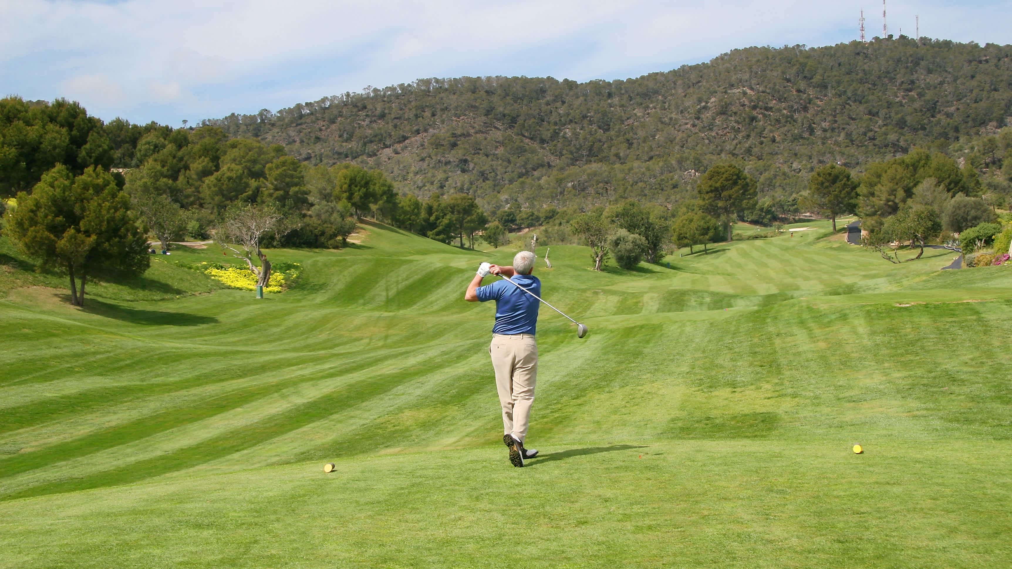 Golfer beim Abschlag von hinten gesehen