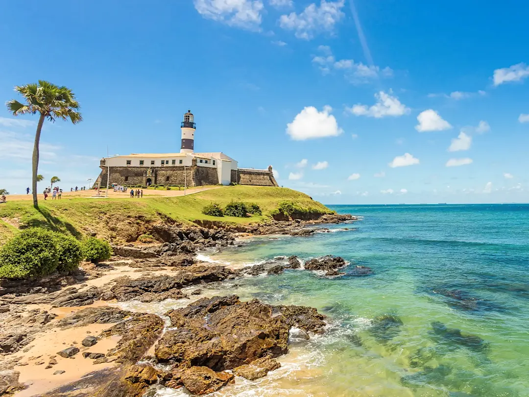 Brasilien, Bahia, Salvador Farol da Barra am Meer mit blauem Himmel. Salvador, Bahia, Brasilien.