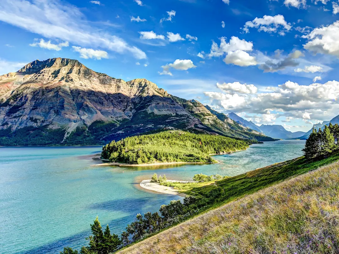 Bergsee mit grünen Inseln und Bergen. Waterton, Alberta, Kanada.
