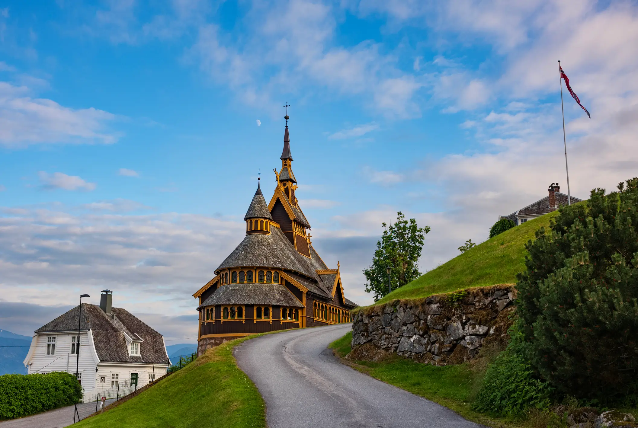 Anglikanische Stein-und Holzerkirche mit gelben Verzierungen gelegen, an einem schmalen Pfad