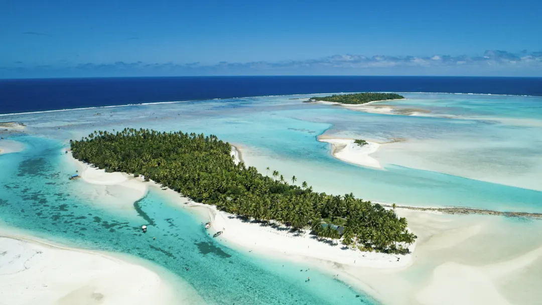 Luftbild einer tropischen Insel mit weißem Sandstrand und türkisfarbenem Wasser. Aitutaki, Cookinseln.