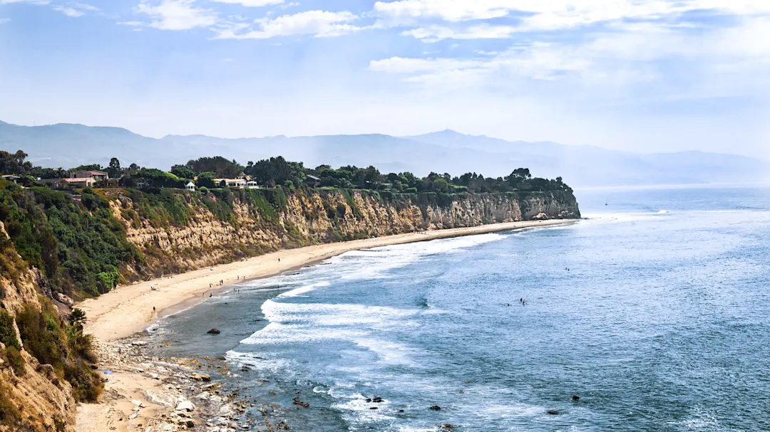 Küstenlinie mit goldenen Klippen, Sandstrand und blauem Meer. Malibu, Kalifornien, USA.