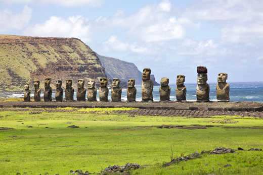 Ahu Tongariki panorama of polynesian Moai Statues standing side by side in a row along the pacific ocean coast under blue summer sky