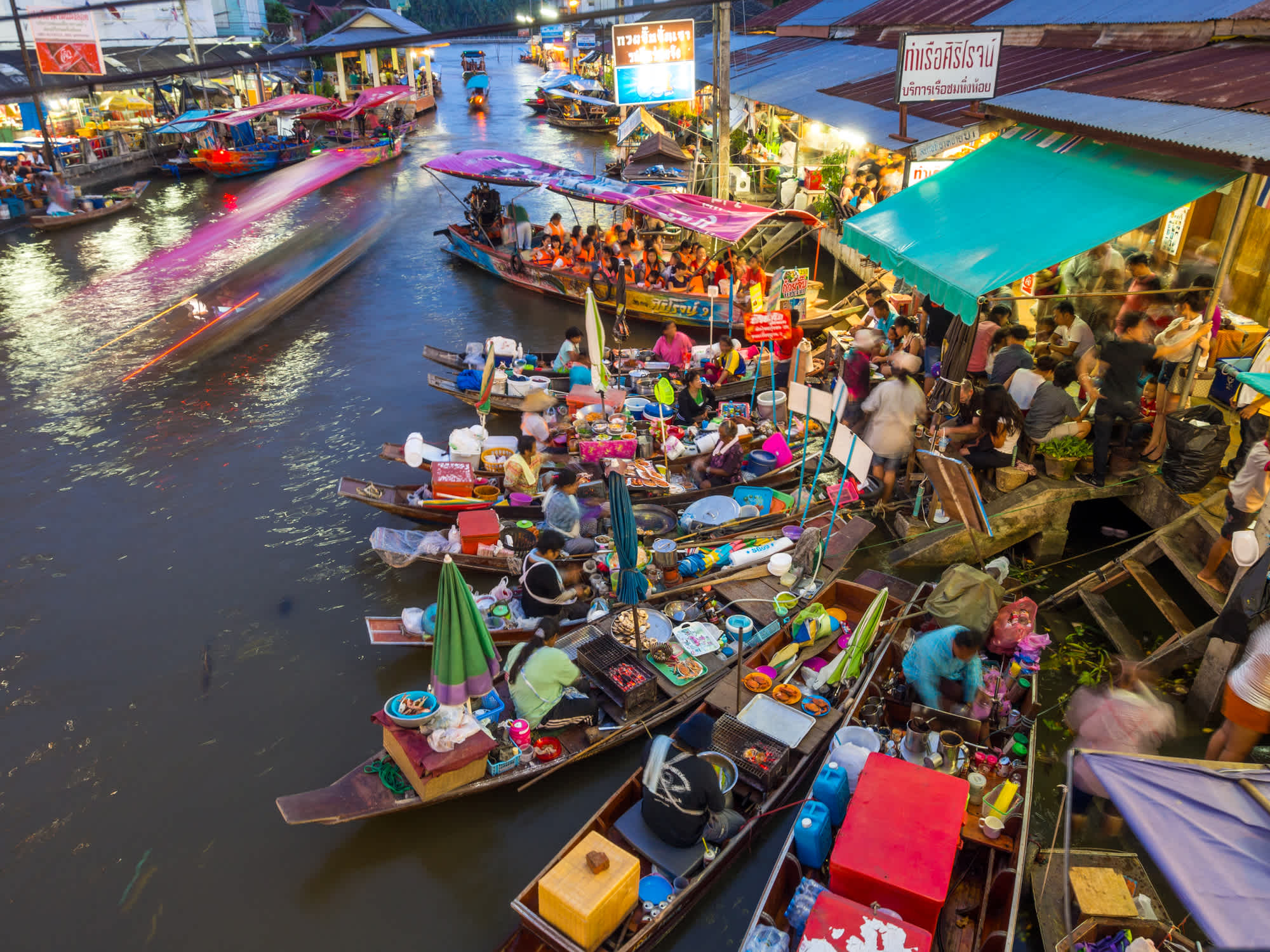 Boote aufgereiht entlang des Flusses im Amphawa Floating Market.