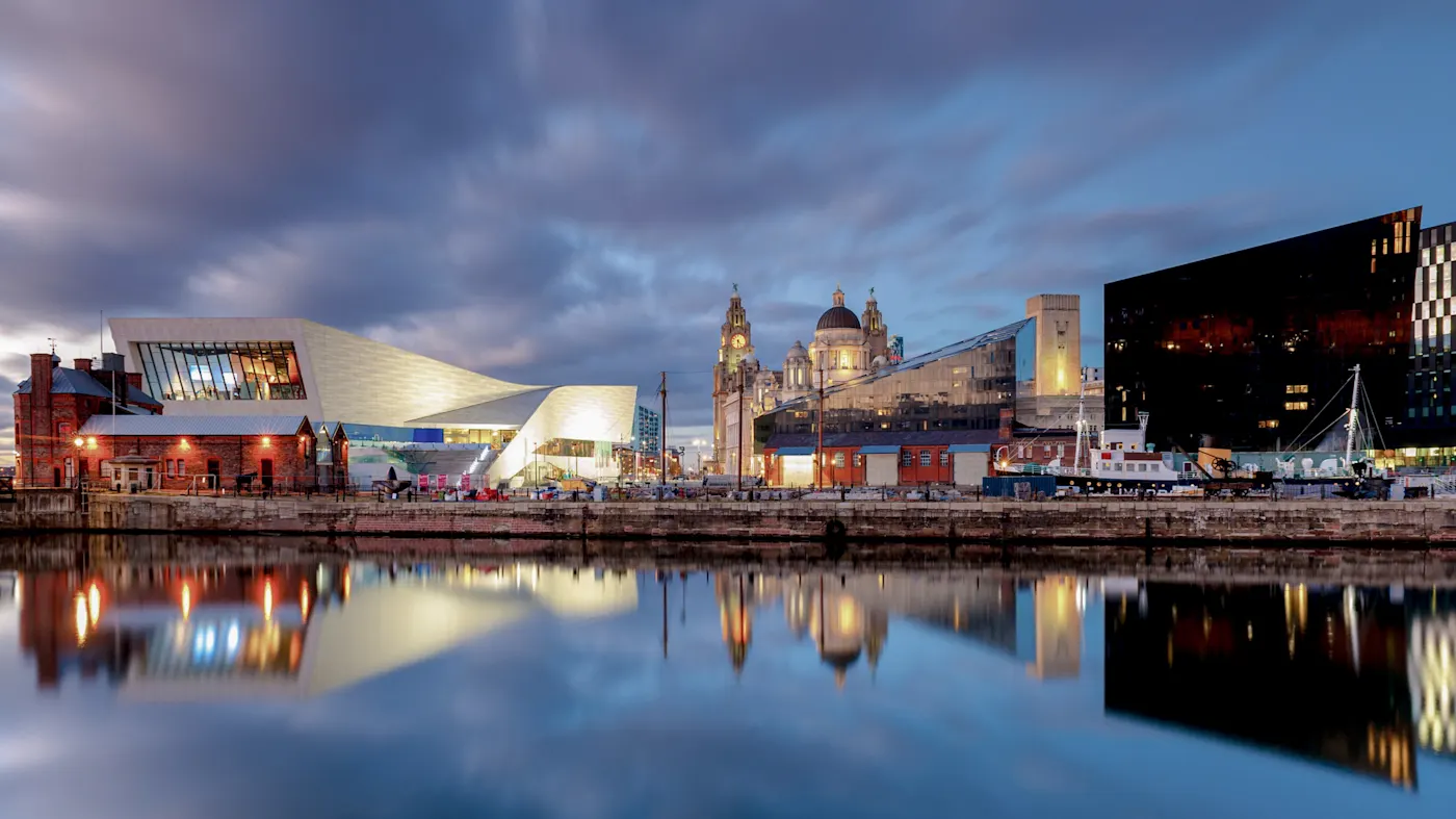 Moderne und historische Gebäude am beleuchteten Hafen mit Spiegelung im Wasser. Liverpool, England, Vereinigtes Königreich.
