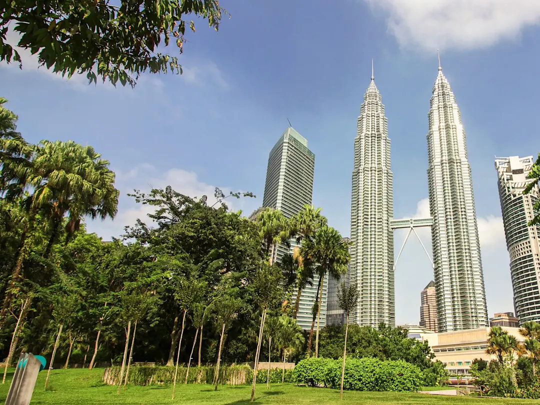 Berühmte Zwillingstürme mit grüner Parklandschaft im Vordergrund. Petronas Towers, Kuala Lumpur, Malaysia.