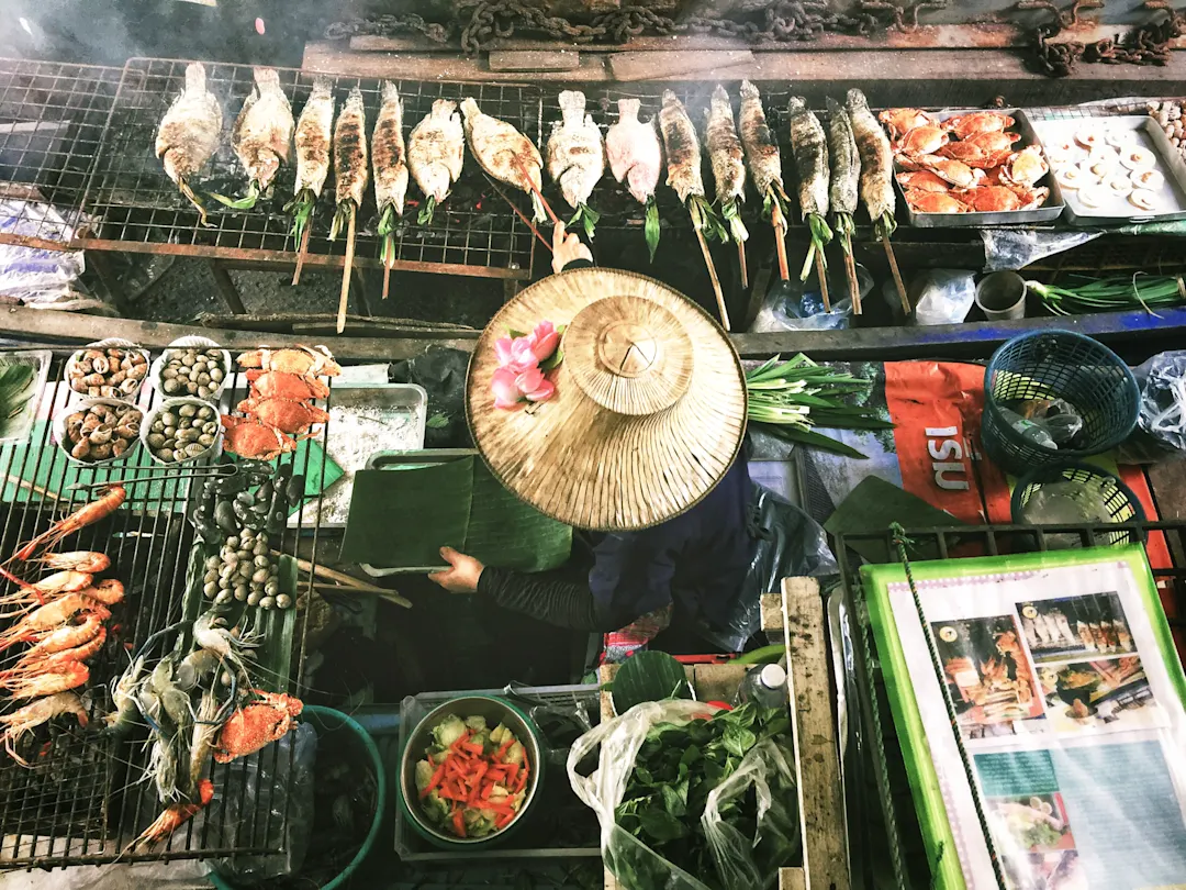 Garküche mit gegrilltem Fisch und Meeresfrüchten, Verkäuferin mit Strohhut, Bangkok, Thailand