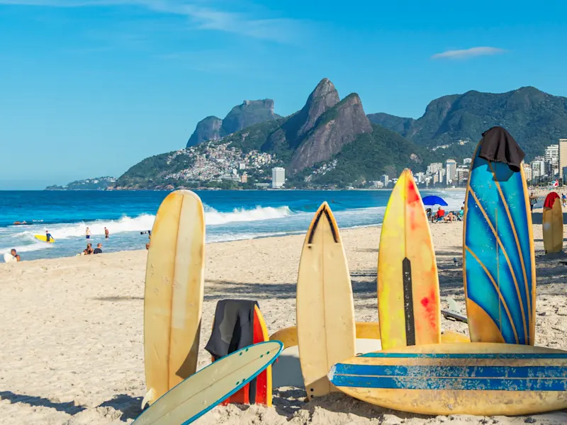 Brasilien, Rio de Janeiro, Ipanema-Strand Surfbretter im Sand mit Blick auf das Meer und die Berge von Rio de Janeiro. Ipanema-Strand, Brasilien.