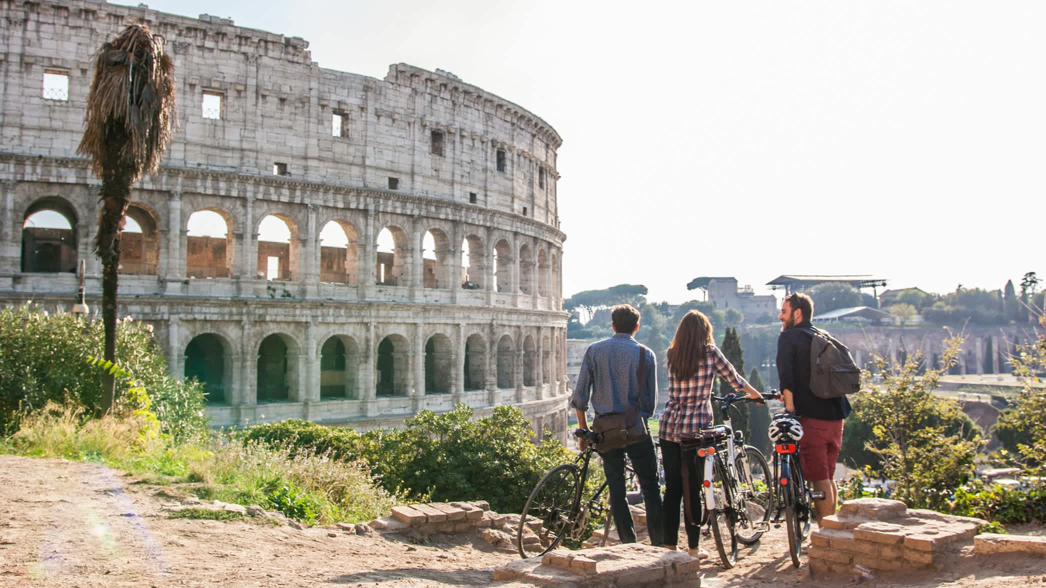 3 Freunde mit Fahrrädern vor dem Kolosseum