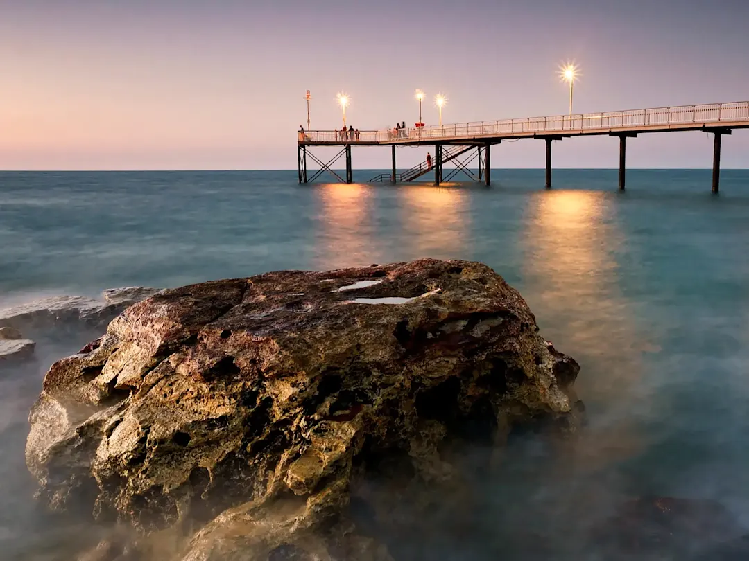 Steg am Meer bei Sonnenuntergang mit Lichtern. Darwin, Northern Territory, Australien.
