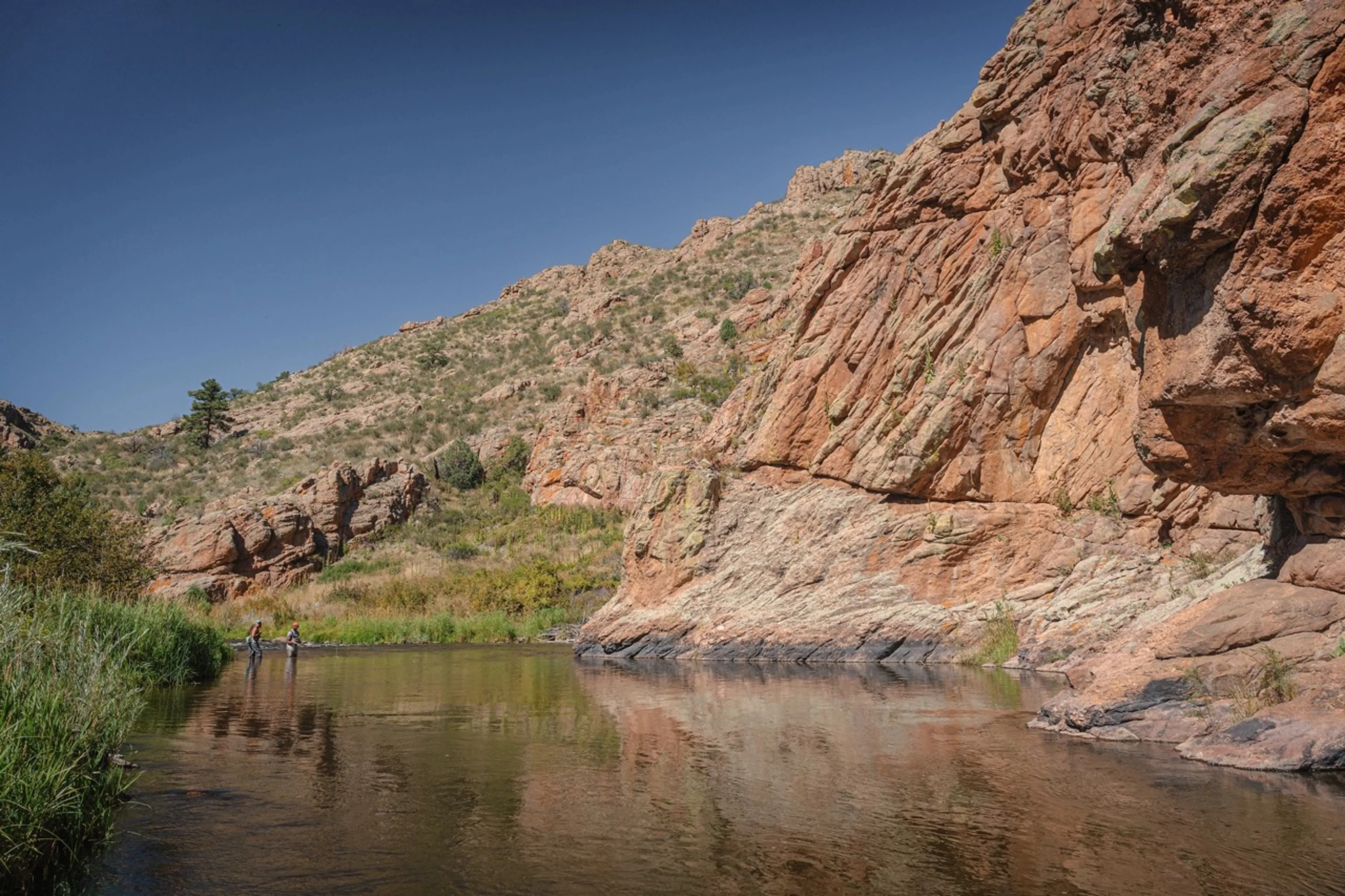 Scenic landscape of water at the base of red rocks