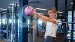 Girl swinging kettle bell at studio floor
