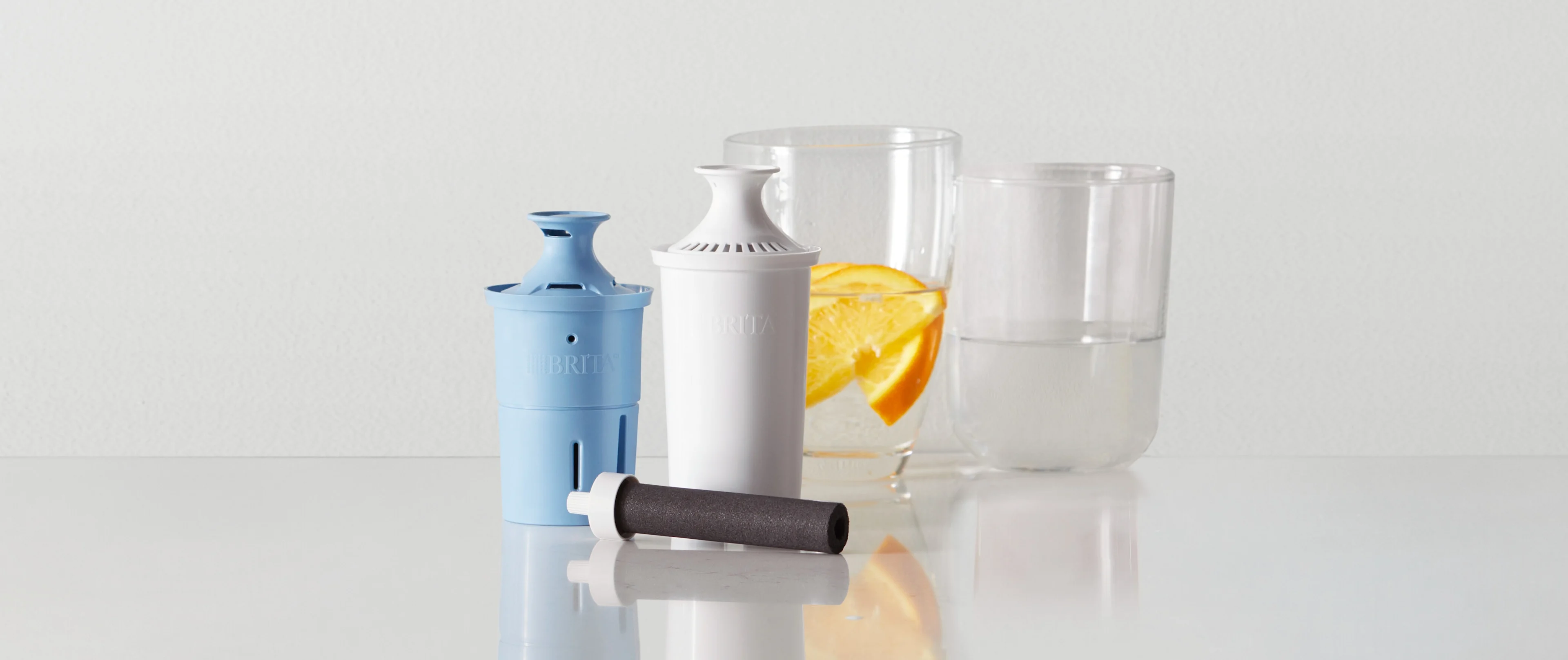 Brita Elite Filter, Original Filter, and Bottle filter on counter, next to two water glasses.