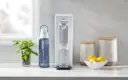 Grey Brita Hub™ Compact Countertop Water Filter System on kitchen counter next to Brita water bottle.