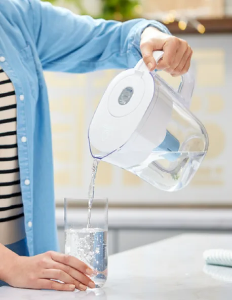 A person pouring water into a glass