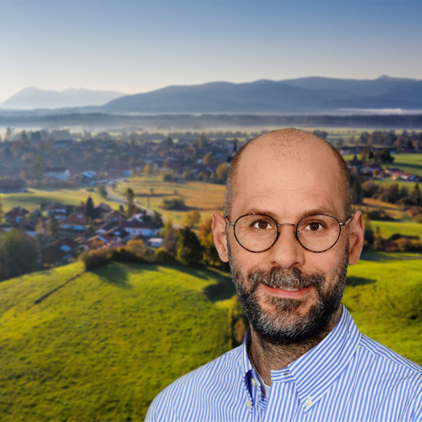 Dr. Tobias Weimann im Profil vor einem ländlichen Hintergrund