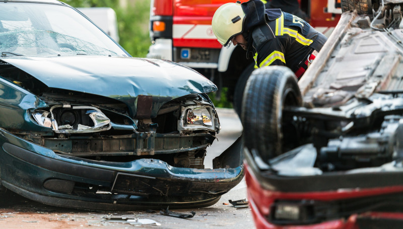 Ein Feuerwehrmann steht zwischen zwei Autowracks