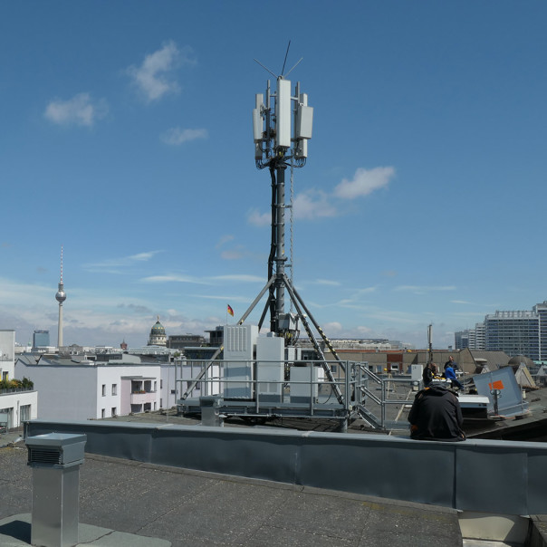 Transmission tower rises into the blue sky above the rooftops of Berlin.