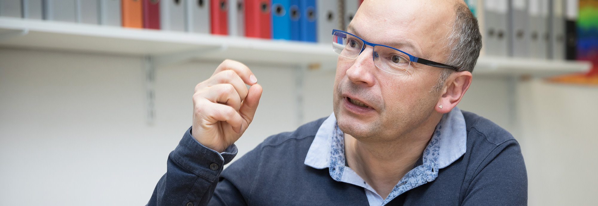 Der Schweizer Forscher Martin Röösli sitzt am Schreibtisch in seinem Büro und klärt im Interview darüber auf, wie Strahlung wirkt und wer Grenzwerte festlegt.