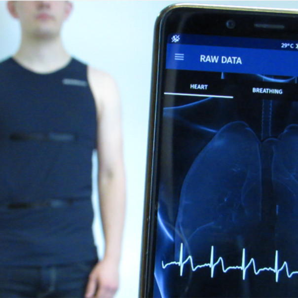 Ein Mann trägt eine EKG-Weste. Die Daten werden auf ein Smartphone übertragen.