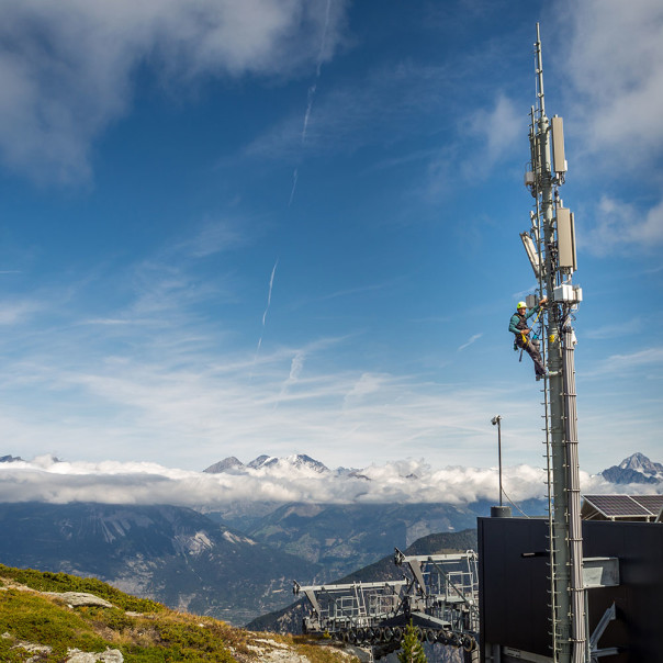 A cell tower is rising into the blue sky against a mountain backdrop. Find out here what conditions have been created by politicians and authorities and how operators are building the 5G network.