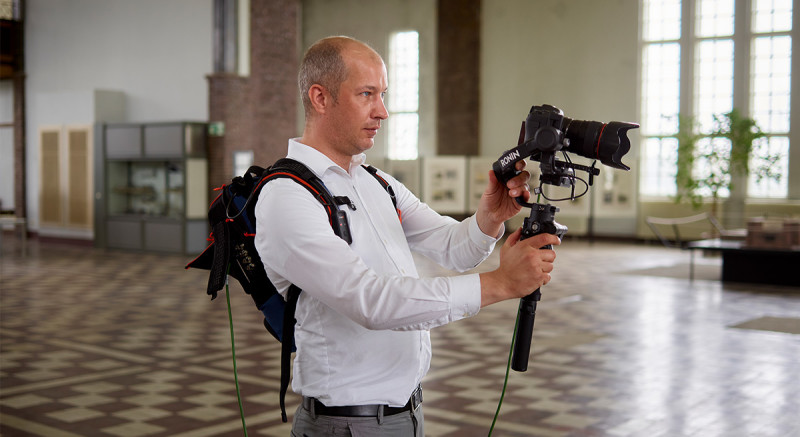 Daniel Wolbers hält eine Kamera und trägt einen Rucksack, der das Livevideo überträgt.