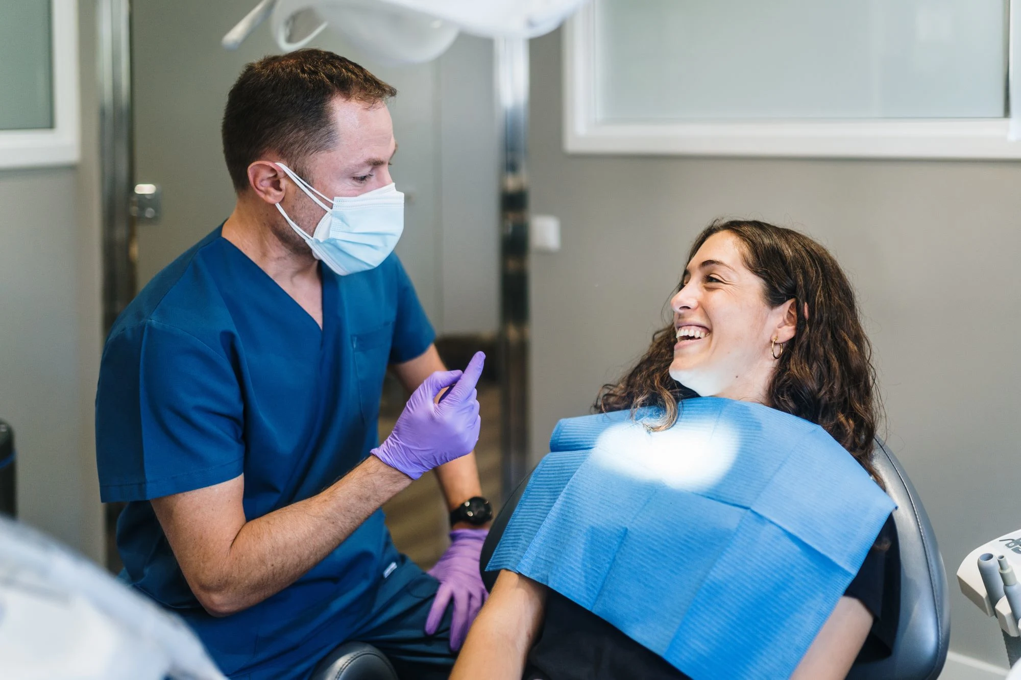 Male dentist discussing oral health with female patient 
