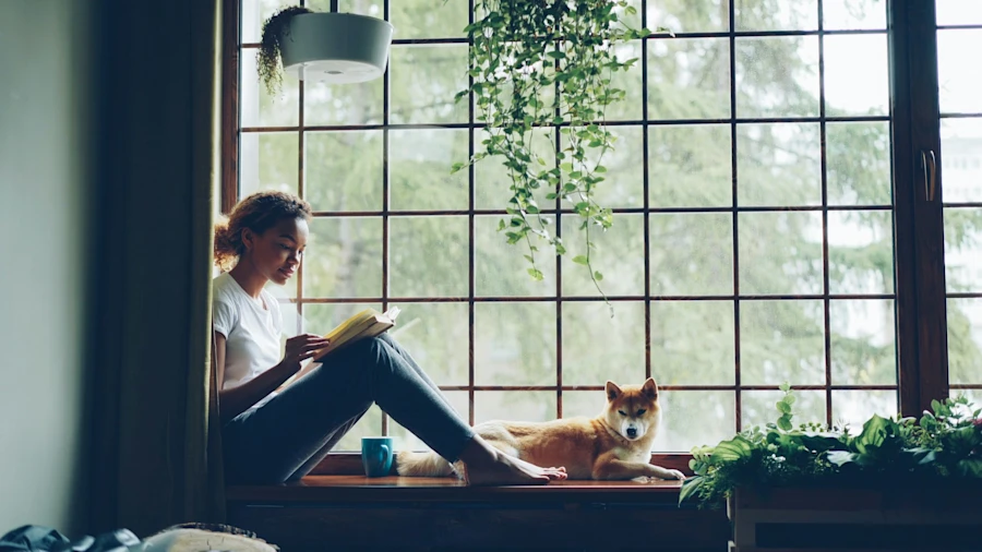 A woman reading near a dog