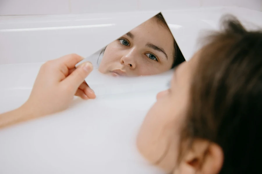 A woman looking at herself on a small mirror