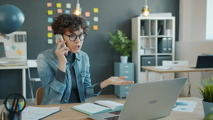 A woman in an office calling a client