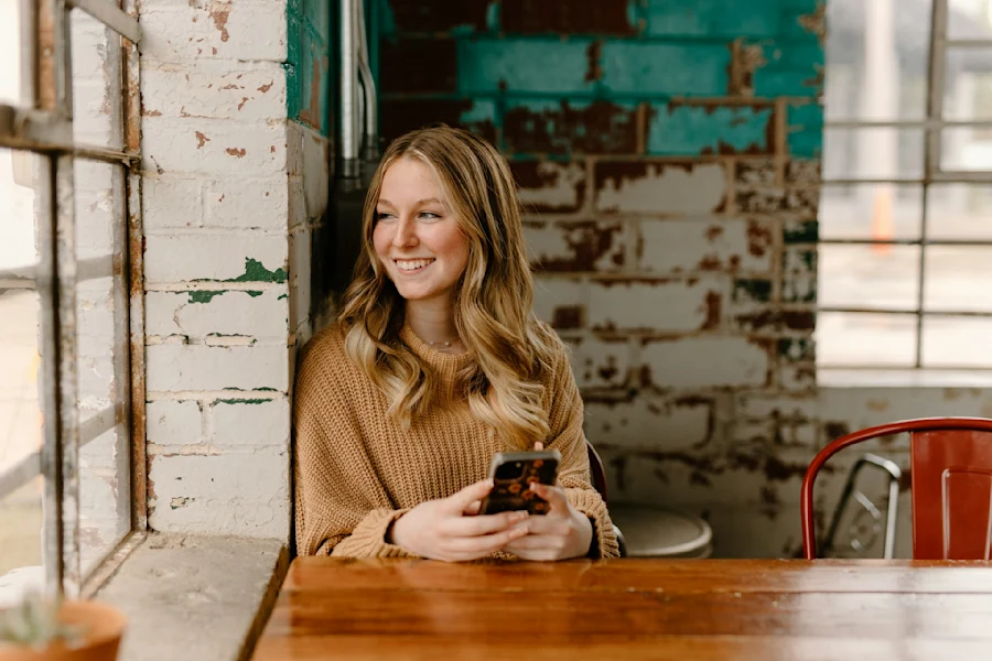 A woman smiling holding a phone
