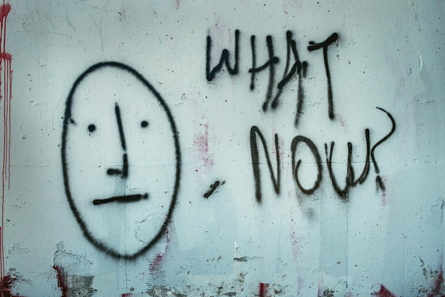 A graffiti that says WHAT NOW