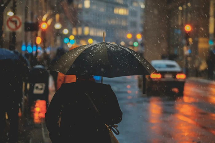 A man holding an umbrella under the rain