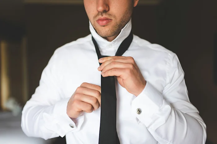 A man putting on a tie