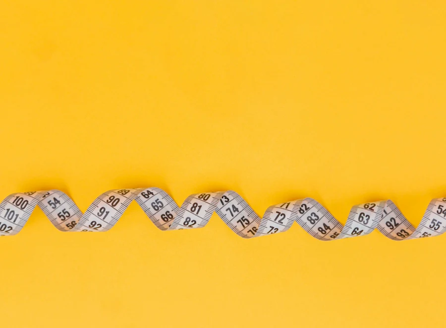A measuring tape on a yellow background