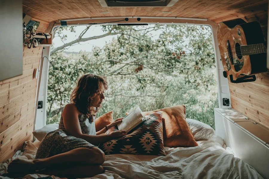 A woman studying in the back of a van
